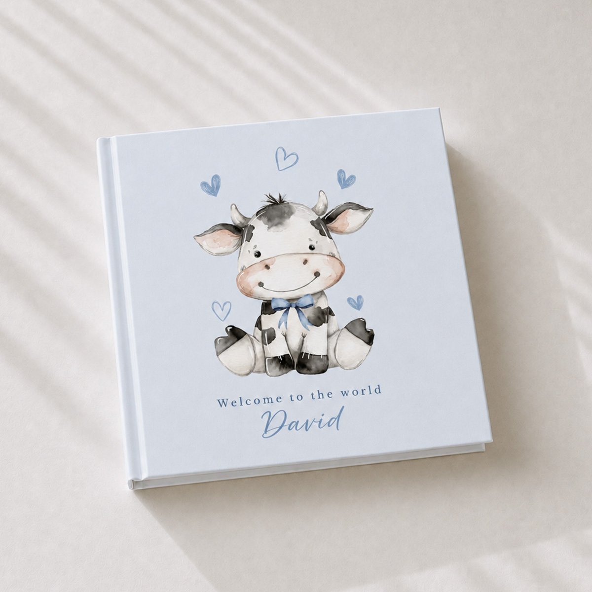 Personalised baby boy keepsake book with a cow illustration